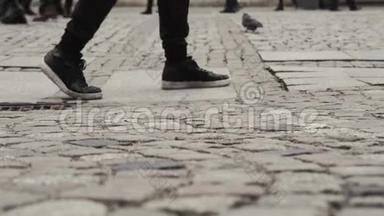 一个人走路的时候脚跟着一个旅行者走在一条街区的路上